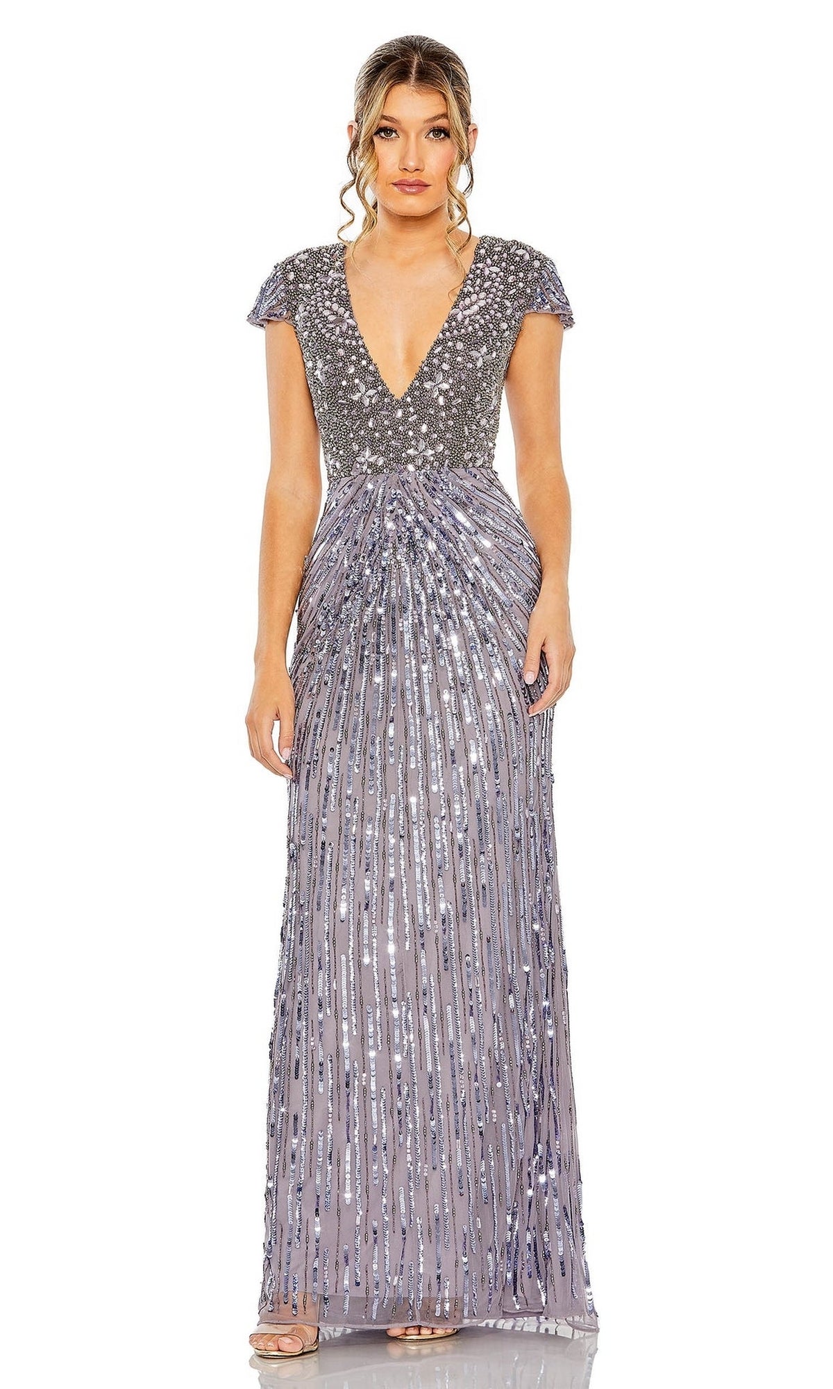 A woman stands against a white background wearing the Mac Duggal Heather Gray Sequin Formal Dress 93914, a floor-length gown with a beaded bodice, sequin skirt, short sleeves, deep V-neck, and pleated accents.